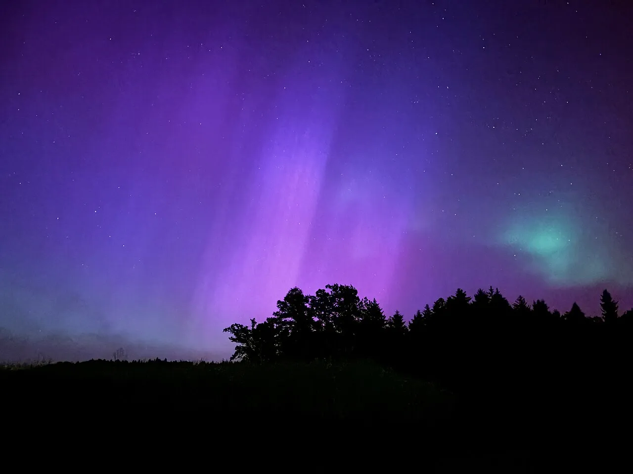 Noorderlicht, groen en rood oplichtend boven Winterthur in Zwitserland